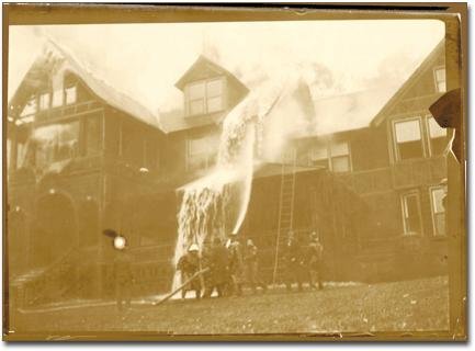 Firefighters use a hose to spray water onto the Bischwind Villa as the historic building is engulfed in flames.